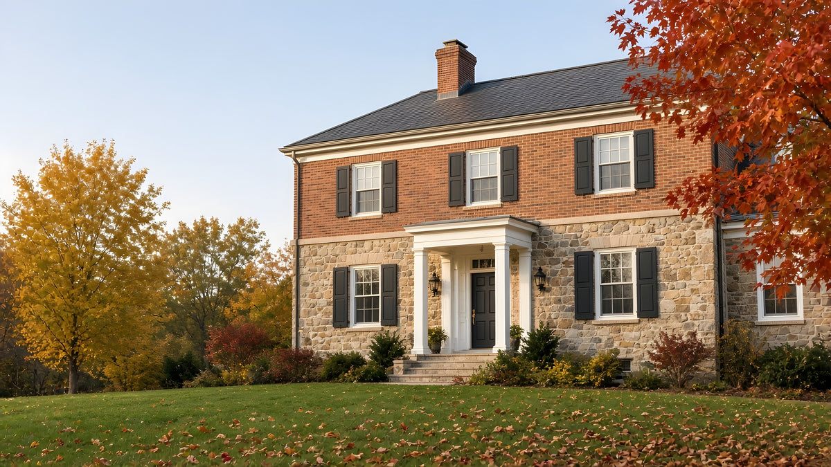 Fieldstone and brick Colonial house in fall